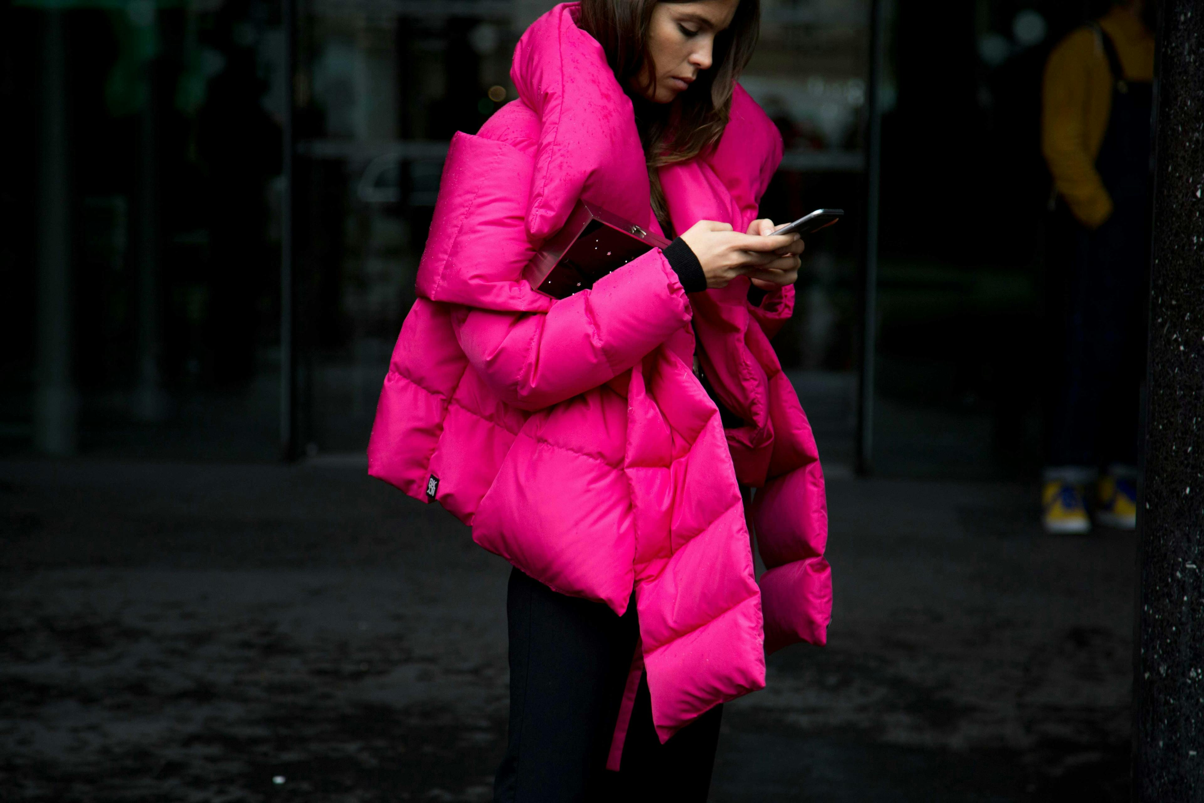 clothing apparel person human coat overcoat jacket phone electronics